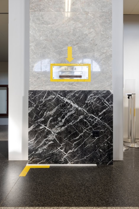 Cais postal avec revêtement en marbre noir et blanc, dans un environnement moderne.