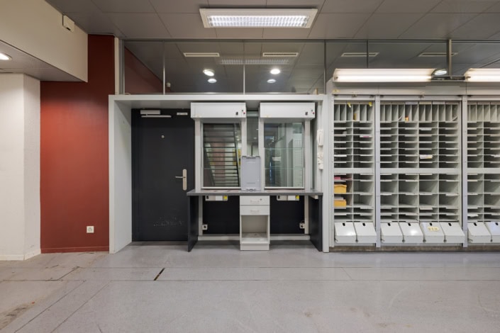 Paire de fenêtres de sécurité avec guichet dans un bureau administratif à Lausanne.