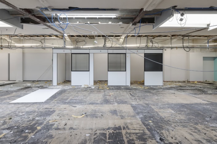 Tension de câbles et travaux en cours dans un espace de bureau en rénovation.