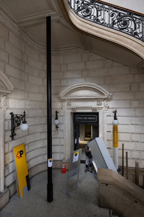Ancien hall d'entrée d'une poste avec une architecture élégante et des détails en fer forgé.