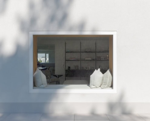 Fenêtre moderne avec deux coussins blancs sur un rebord à l'intérieur d'un espace intérieur minimaliste