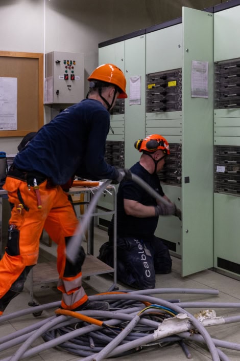 Travailleurs en intervention électrique dans un centre technique professionnel.
