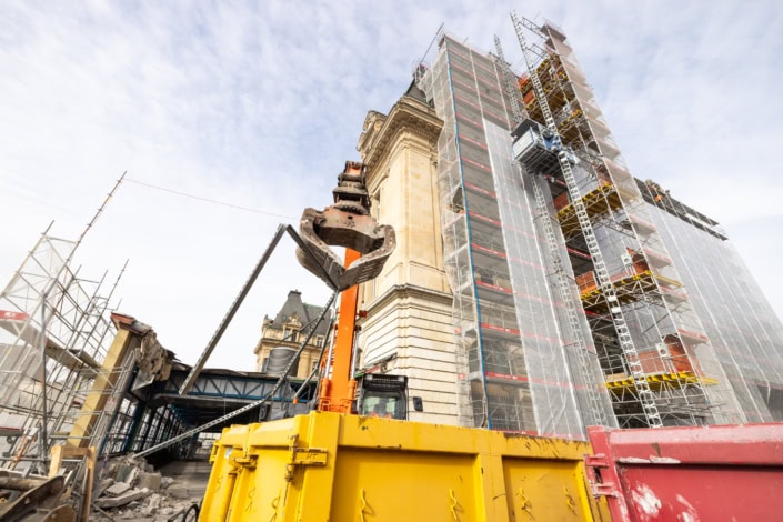 Îlot de construction avec échafaudages et excavatrice à Lausanne.