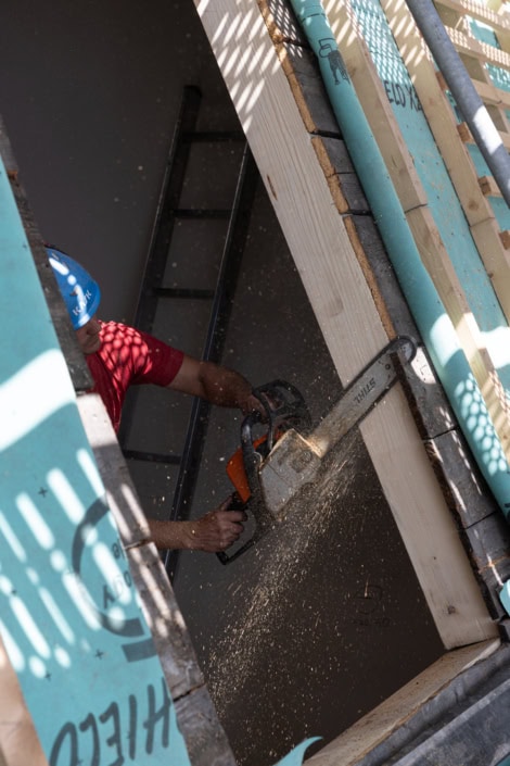 Travail de construction avec scie électrique par un ouvrier.