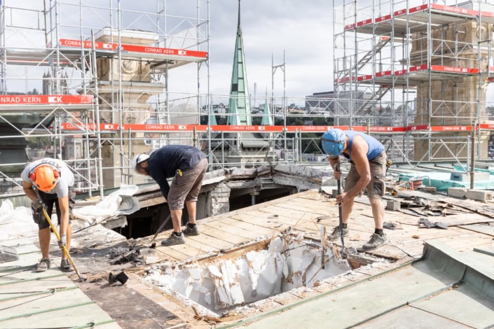 ouvriers en activité sur la toiture d'un bâtiment historique en cours de rénovation