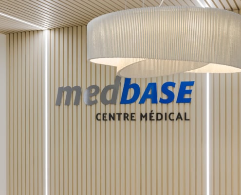 Enseigne en relief du centre médical Medbase avec un éclairage moderne en arrière-plan.
