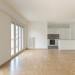 Luminosité naturelle dans un appartement moderne avec cuisine ouverte à Lausanne.