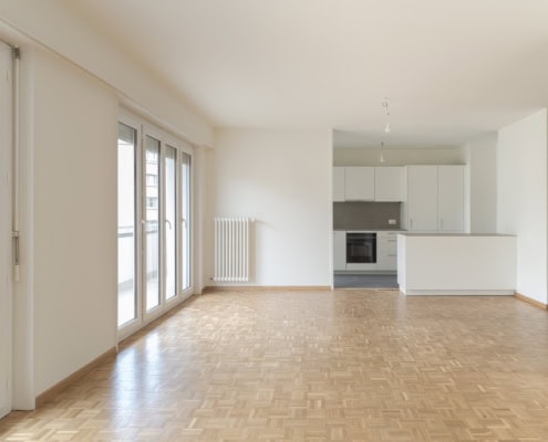 Luminosité naturelle dans un appartement moderne avec cuisine ouverte à Lausanne.