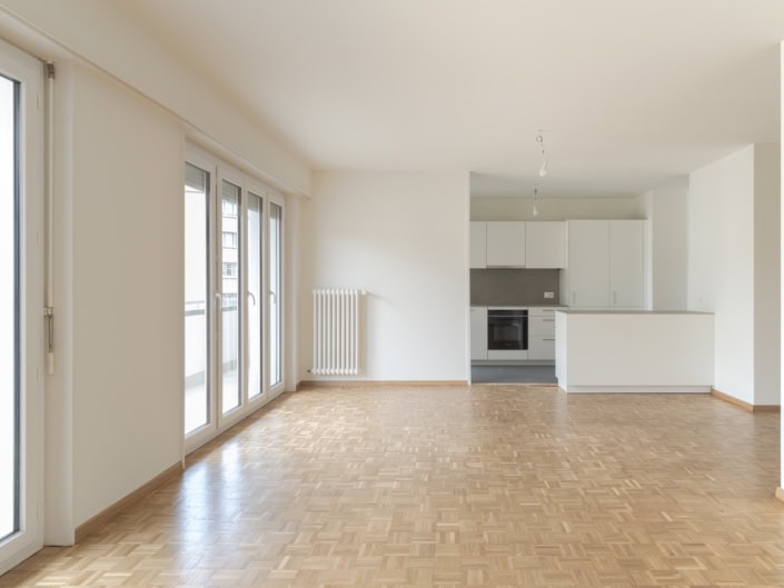 Luminosité naturelle dans un appartement moderne avec cuisine ouverte à Lausanne.