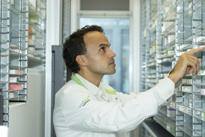 Pharmacien vérifiant des médicaments dans une pharmacie à Lausanne.
