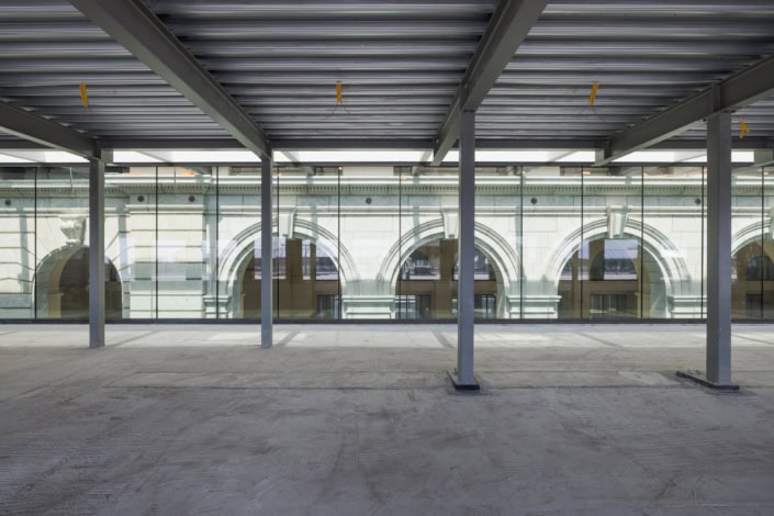 Un espace moderne avec structure métallique et vue sur bâtiments historiques.