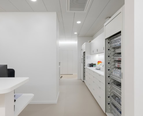 Intérieur d'un bureau moderne avec des meubles de rangement blancs et un sol clair.