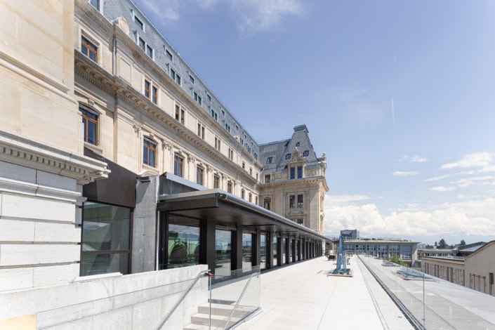 Vue extérieure d'un bâtiment historique avec terrasse ensoleillée à Lausanne.