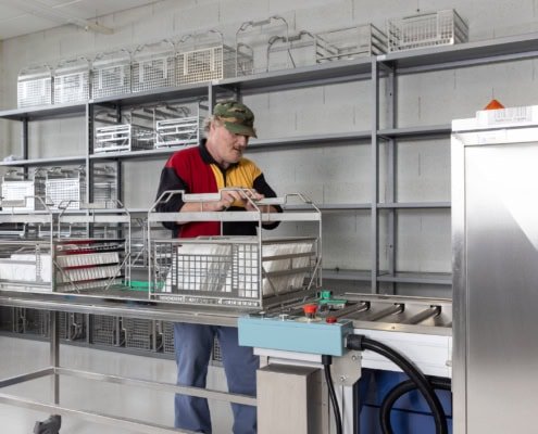 Employé en train de procéder à des bains de nettoyage horloger à Sainte-Croix en Suisse romande