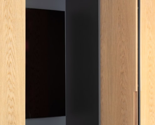 Armoire en bois avec des portes en chêne ouvertes, révélant un espace de rangement intérieur.