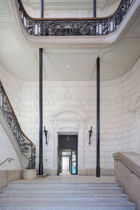 Un intérieur élégant avec escalier en pierre et balustrade en fer forgé à Lausanne.