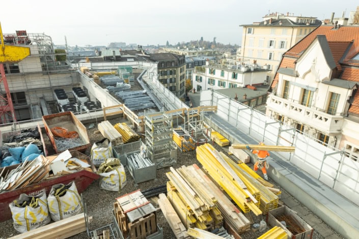 Travail de construction sur le toit d'un bâtiment à Lausanne, vue urbaine.