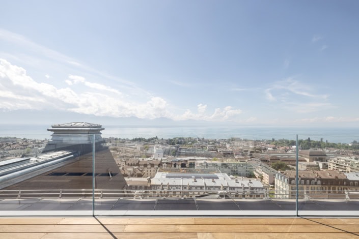 Vue panoramique de Lausanne depuis un balcon avec vue sur la ville et le lac.