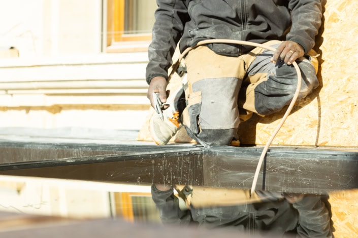 Travailleur en construction posant une fenêtre en extérieur.