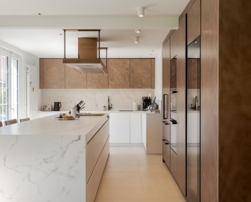 Cuisine moderne avec des armoires en bois et un îlot central en marbre blanc.