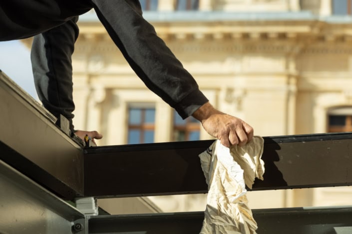 Travail de peinture en extérieur sur un bâtiment historique à Lausanne.