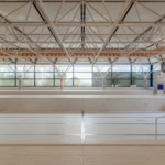 Intérieur d'une piscine vide avec des murs en carrelage et une structure en acier au plafond.