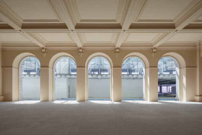 Vue intérieure d'une salle lumineuse avec arches et grandes fenêtres à Lausanne.