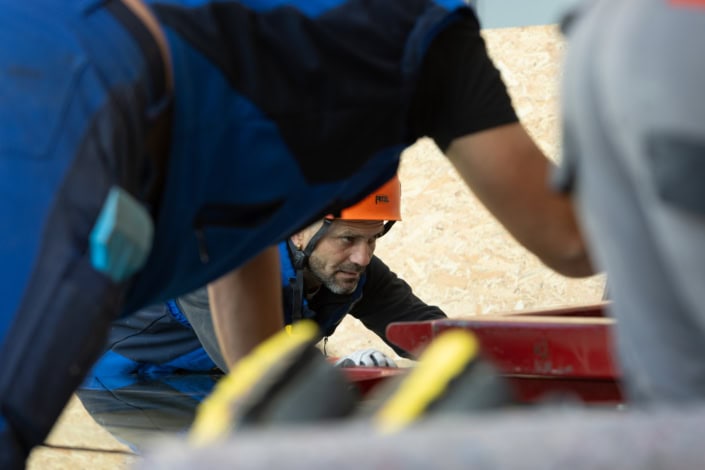 Escaladeur en terrain rocheux portant casque de sécurité, activité intense.