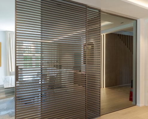 Porte coulissante en verre avec des lattes horizontales dans un intérieur moderne.