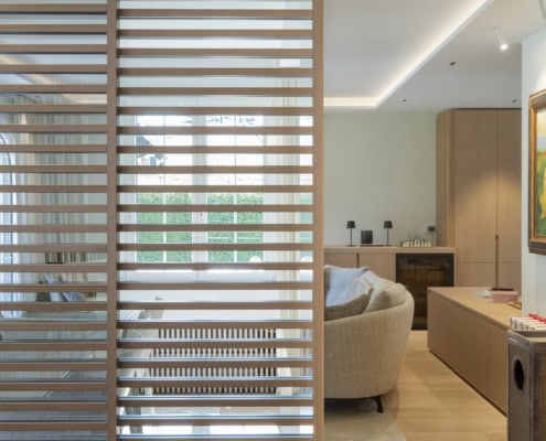 Paroi en bois à lattes séparant un espace de vie dans un intérieur moderne et lumineux.