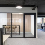 Espace de bureau moderne avec salle de réunion vitrée et ambiance professionnelle.