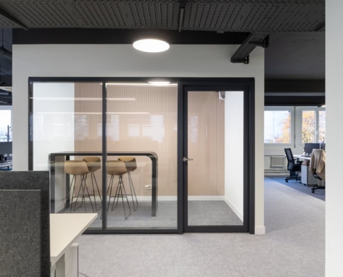 Espace de bureau moderne avec salle de réunion vitrée et ambiance professionnelle.