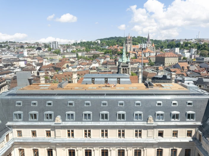 Vue panoramique de Lausanne avec bâtiments historiques et ciel bleu en arrière-plan.