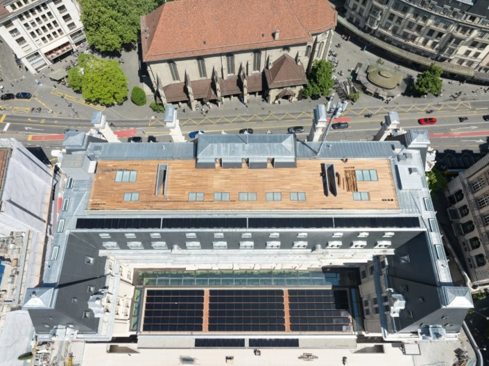 Toit-terrasse avec panneaux solaires sur un bâtiment à Lausanne, vue aérienne.