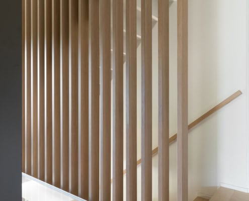 Clôture en bois avec des lattes verticales et un escalier en bois à l'arrière-plan.