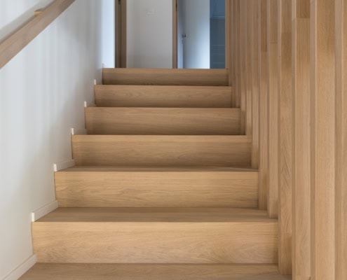 Escalier en bois clair avec des marches en bois et une rampe en bois.