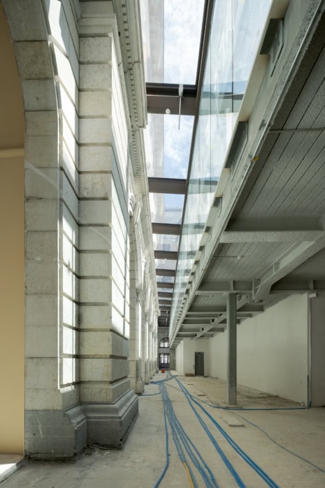 Vue architecturale d'un bâtiment moderne avec structure en acier et câbles bleus au sol.