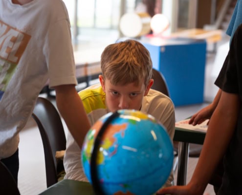 enfant en train de regarder un mappemonde