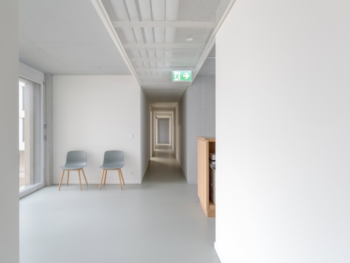 Chaises grises dans un intérieur minimaliste lumineux à Lausanne.