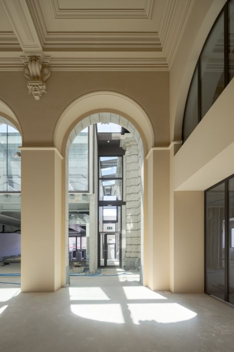 Photographe professionnel à Lausanne - intérieur lumineux avec arches et grandes fenêtres.