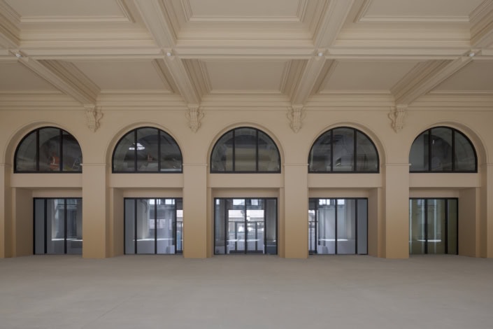 Un bâtiment avec de grandes fenêtres en arches dans un intérieur lumineux et spacieux.