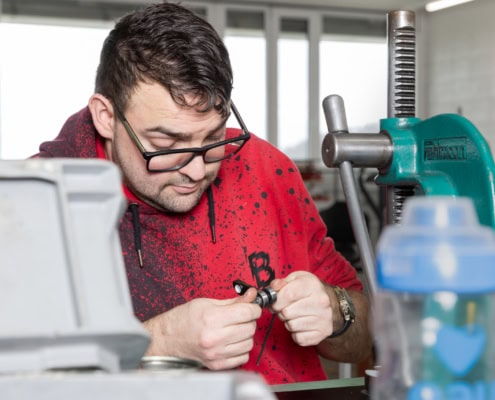 employé en train d'assembler des pièces dans un atelier mécanique