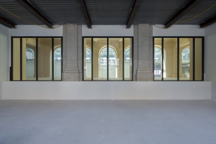 Un bâtiment moderne avec grandes fenêtres en verre et structure en béton à Lausanne.