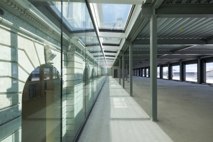 Vue d'un espace moderne avec grandes fenêtres en verre et structure métallique à Lausanne.
