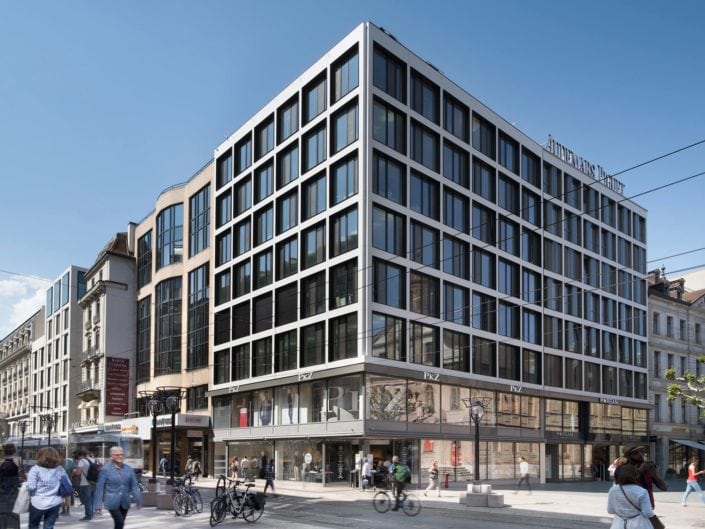 architecture à Genève montrant un angle de bâtiment avec façades adjacentes et stores levés