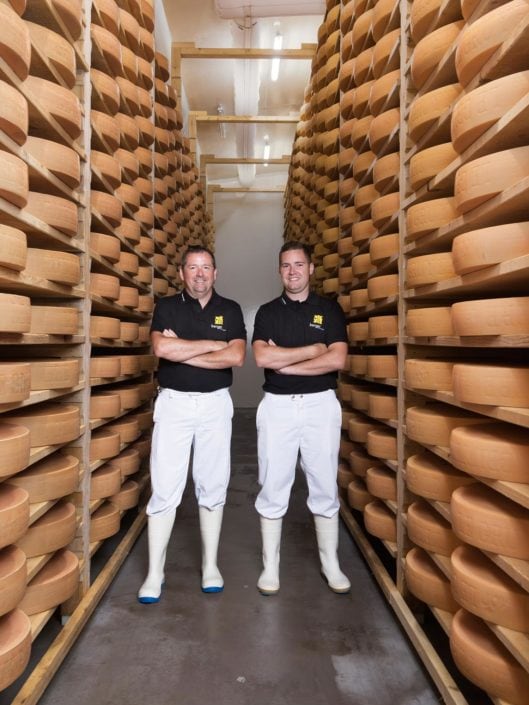Portrait corporate de fromagers dans une cave à fromages