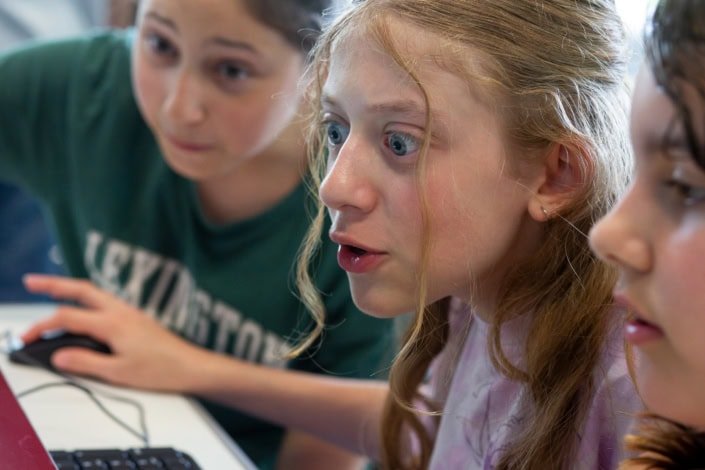 Enfants au regard fasciné devant un écran d'ordinateur