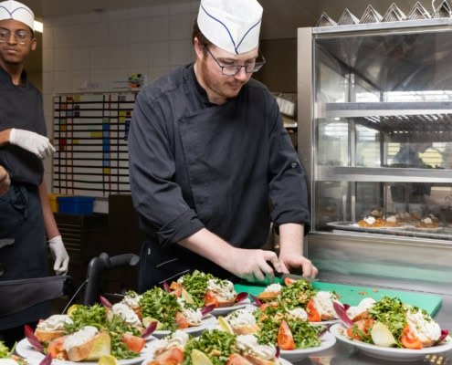 cuisinier en train de couper un légume